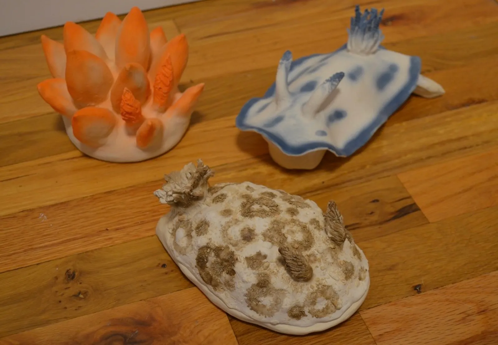 Three small ceramic nudibranch sculptures